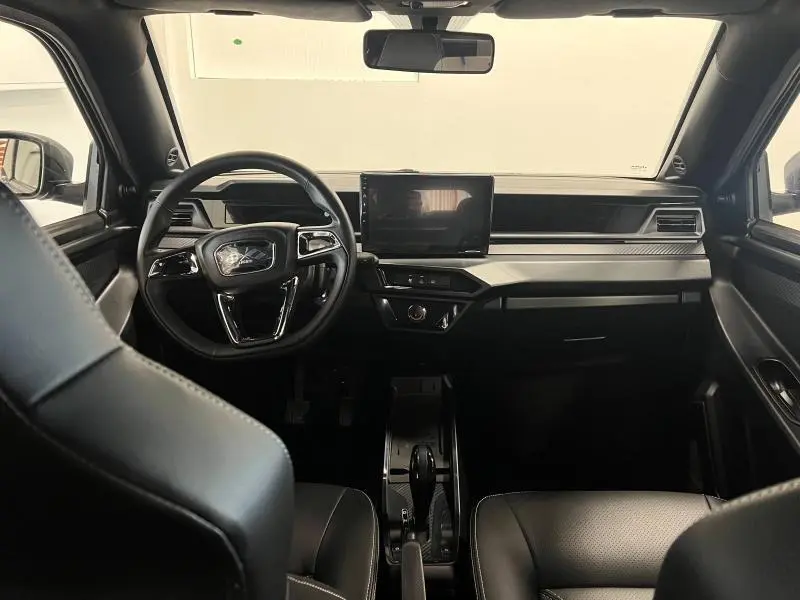 Vue intérieure avant du tableau de bord gris du Ligier JS50 Sport Elite E5+ 2025 avec écran tactile central et volant multifonction.