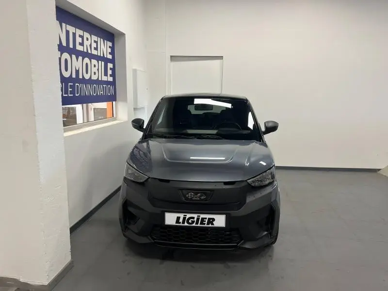 Vue frontale d'une Ligier JS50 Sport Elite E5+ gris métallisé, avec calandre noire et logo distinctif visible.