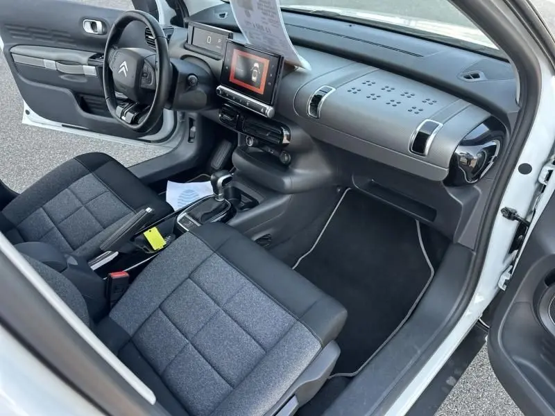 Intérieur avant droit d'une Citroën C4 Cactus blanc 2018, avec sièges tissu bi-ton et tableau de bord moderne.