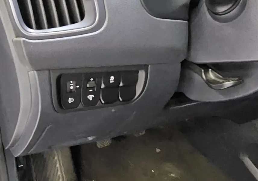 Vue rapprochée du tableau de bord côté gauche de la KIA RIO III noire, montrant les commandes de réglage et ventilation.