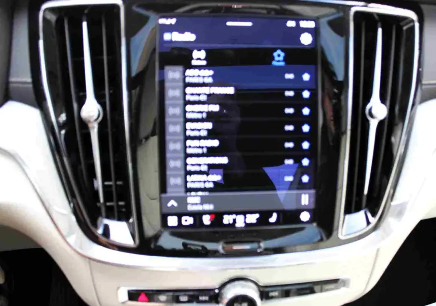 Écran tactile central et aérateurs chromés du tableau de bord clair d'une Volvo S60 gris métal 2024 hybride rechargeable.