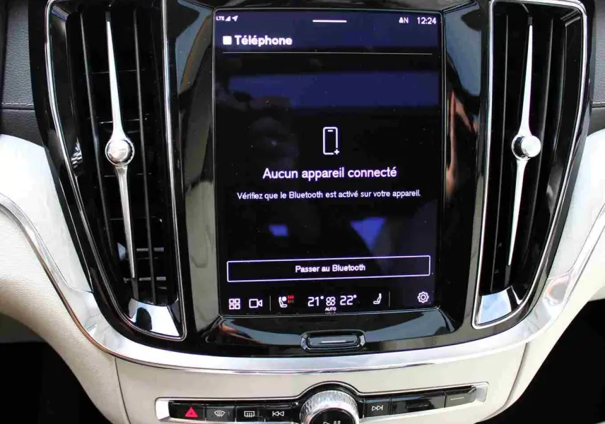 Vue rapprochée de l'écran tactile central et des aérateurs noirs d'un Volvo S60 gris métal 2024 hybride rechargeable.