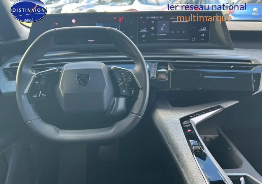 Vue intérieure centrée sur le volant cuir Peugeot et tableau de bord numérique du SUV 5008 blanc okenite 2025.