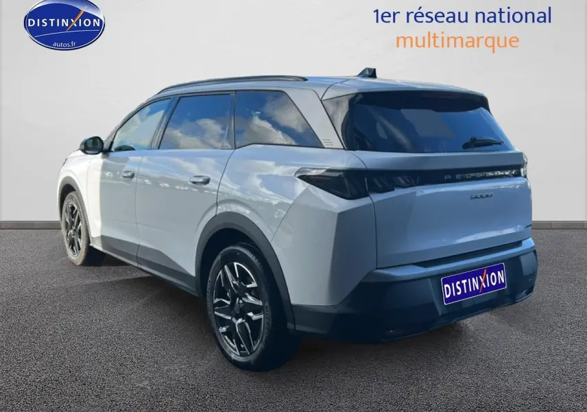 Vue 3/4 arrière droite d’un Peugeot 5008 Hybrid 145 allure blanc okenite avec jantes alu et vitres arrière surteintées.