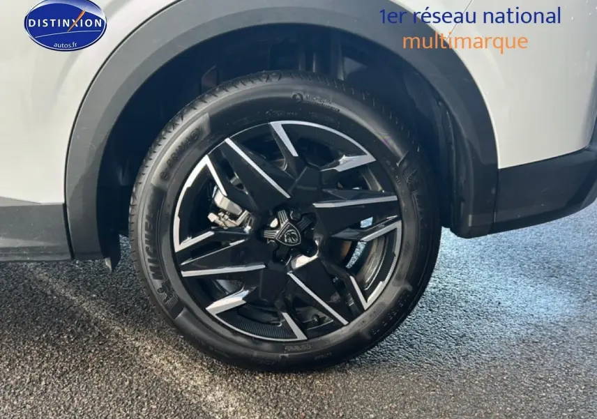 Gros plan sur la roue avant droite avec jante alu noire et argentée du Peugeot 5008 blanc okenite.