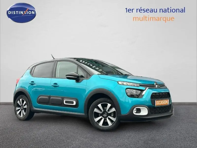 Vue 3/4 avant droite d'une Citroën C3 2023 bicolore Spring Blue et Noir avec jantes alu et protections latérales noires.