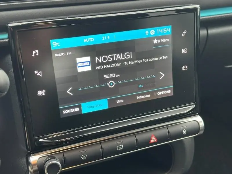 Écran tactile central de la Citroën C3 2023 affichant la radio FM sur fond noir avec commandes tactiles lumineuses.