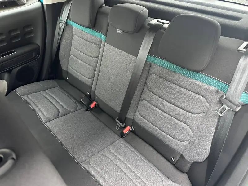 Vue intérieure de la banquette arrière grise avec bande turquoise de la Citroën C3 Shine 2023, côté droit.