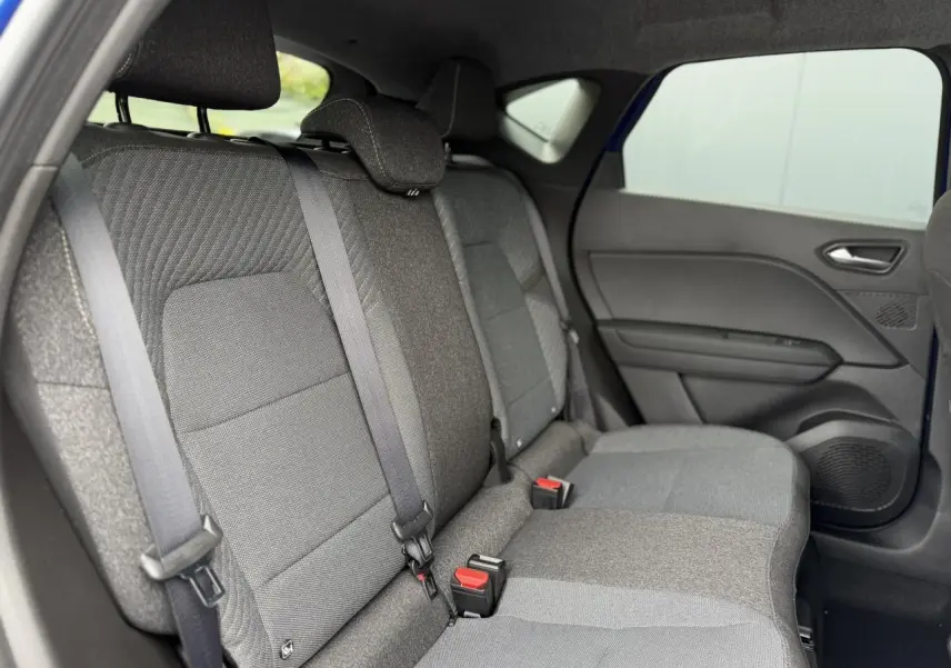 Vue intérieure côté droit des sièges arrière gris du Renault Captur 2026 avec ceinture de sécurité et porte ouvert.