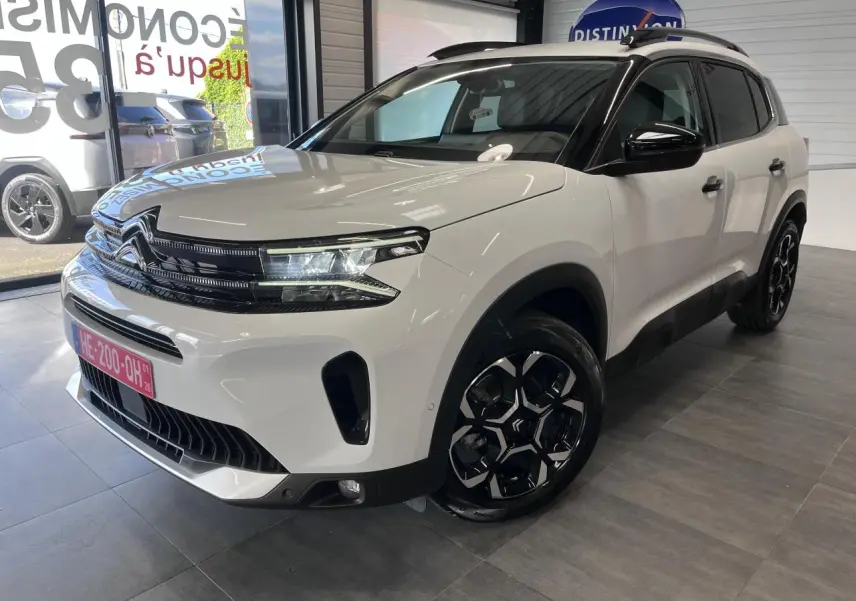 Vue 3/4 avant droite d'un Citroën C5 Aircross blanc nacré avec calandre noire brillante et jantes alliage bi-ton.