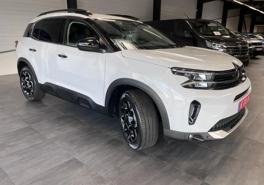 Citroën C5 Aircross blanc nacré en 3/4 avant droit, avec jantes alliage bi-ton et détails noirs brillants.