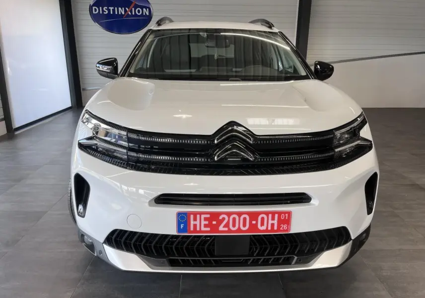 Vue avant d'un Citroën C5 Aircross blanc nacré avec calandre noire brillante et plaques rouges temporaires.