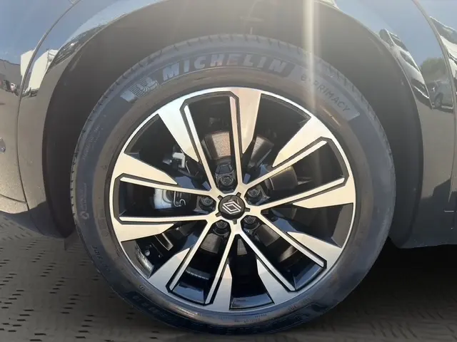 Gros plan sur la roue avant droite noire du Renault Austral 2025 avec jante alliage bicolore et pneu Michelin.
