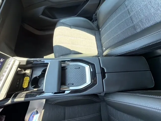 Vue intérieure du Renault Austral 2025 noir, focus sur la console centrale avec zone de recharge par induction et accoudoir cuir.