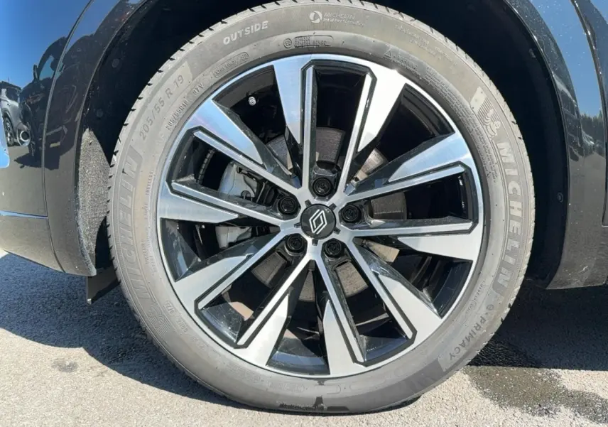 Gros plan sur la roue avant droite noire du Renault Austral 2025 avec jante alliage bicolore et pneu Michelin.