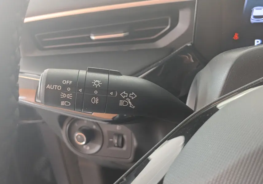 Gros plan sur la commande des feux et clignotants du MG3 1.5L Hybrid+ 195CH Luxury, intérieur gris noir.