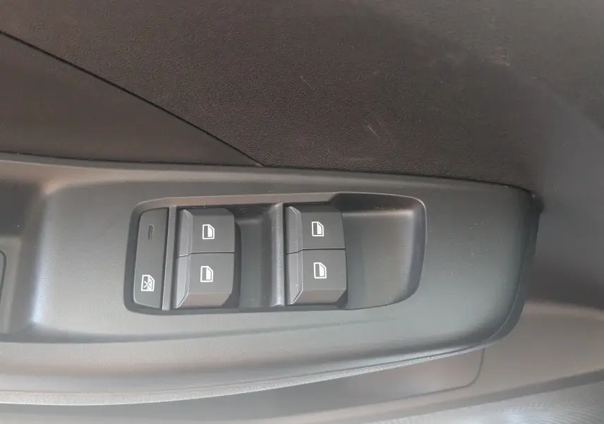 Gros plan sur les commandes des vitres électriques côté conducteur de la MG3 1.5L Hybrid+ 195ch Luxury, intérieur gris noir.