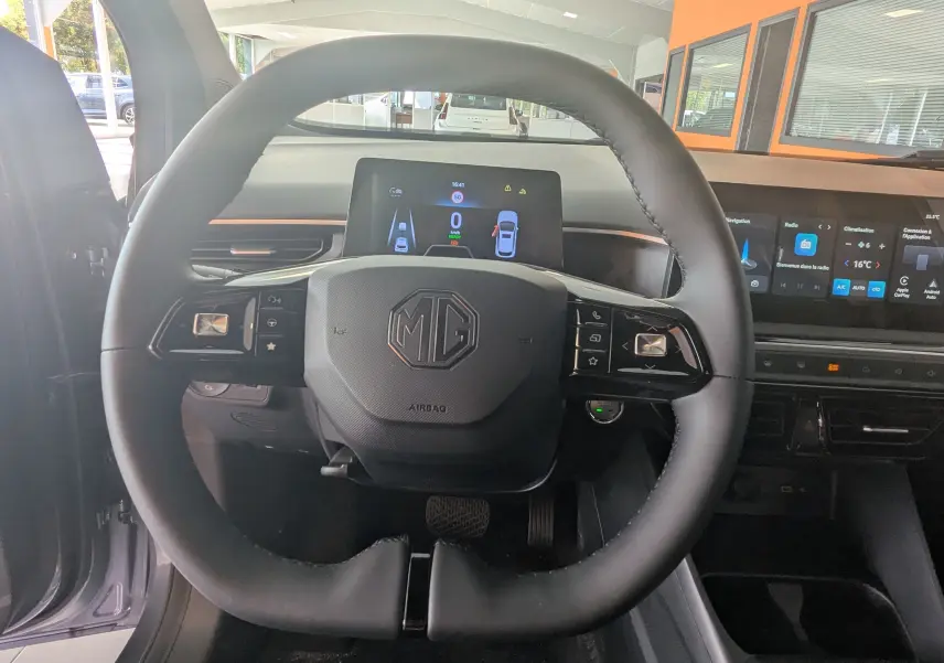 Vue intérieure centrée sur le volant noir du MG3 1.5L Hybrid+ 195ch Luxury avec tableau de bord digital et écran tactile.