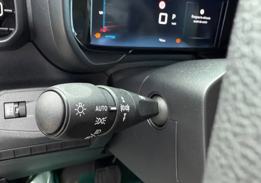 Gros plan sur la commande des phares à gauche du volant dans l'habitacle du Citroën Berlingo Fourgon XL Diesel 2026.
