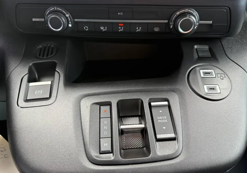 Vue rapprochée de la console centrale noire du Citroën Berlingo Fourgon XL avec commandes de climatisation et boutons de boîte auto.