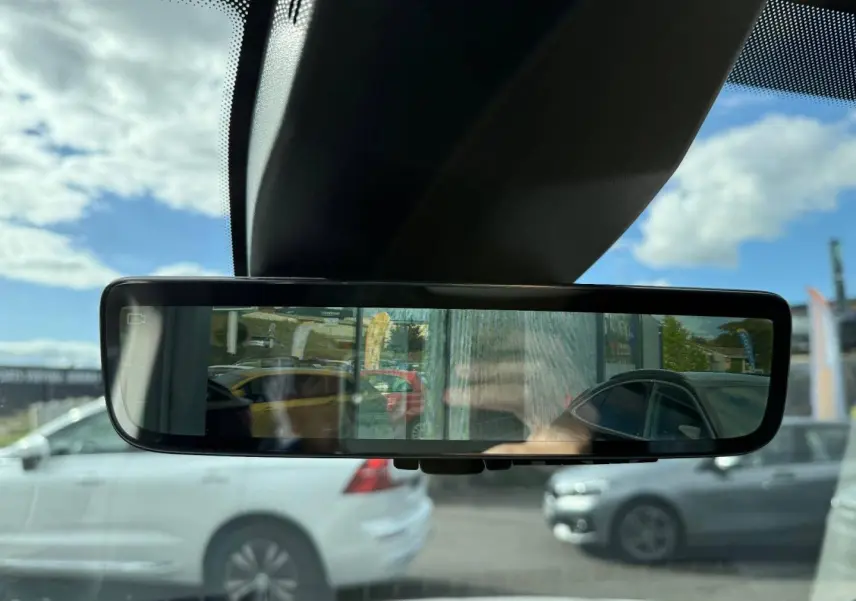 Rétroviseur intérieur numérique montrant une vue arrière avec un Citroën Berlingo Fourgon XL blanc Icy en stationnement.