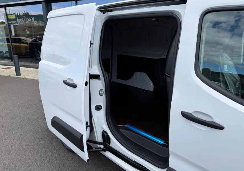 Vue côté droit d’un Citroën Berlingo Fourgon XL blanc Icy avec porte latérale coulissante ouverte montrant l’espace de chargement.