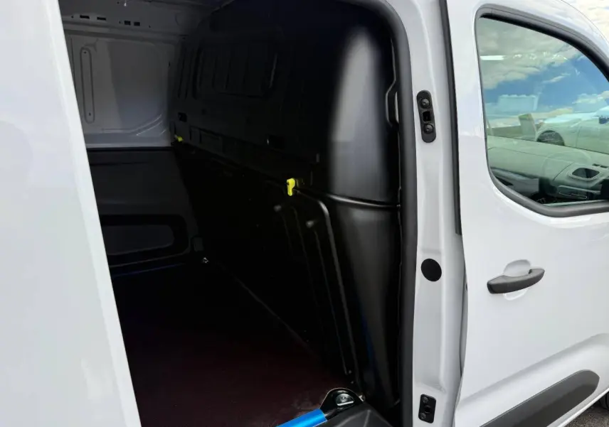 Vue latérale droite du Citroën Berlingo Fourgon XL blanc Icy avec porte coulissante ouverte sur l’espace de chargement.