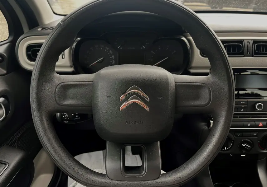 Vue centrée sur le volant noir de la Citroën C3 2017, avec tableau de bord et console centrale visibles en arrière-plan.