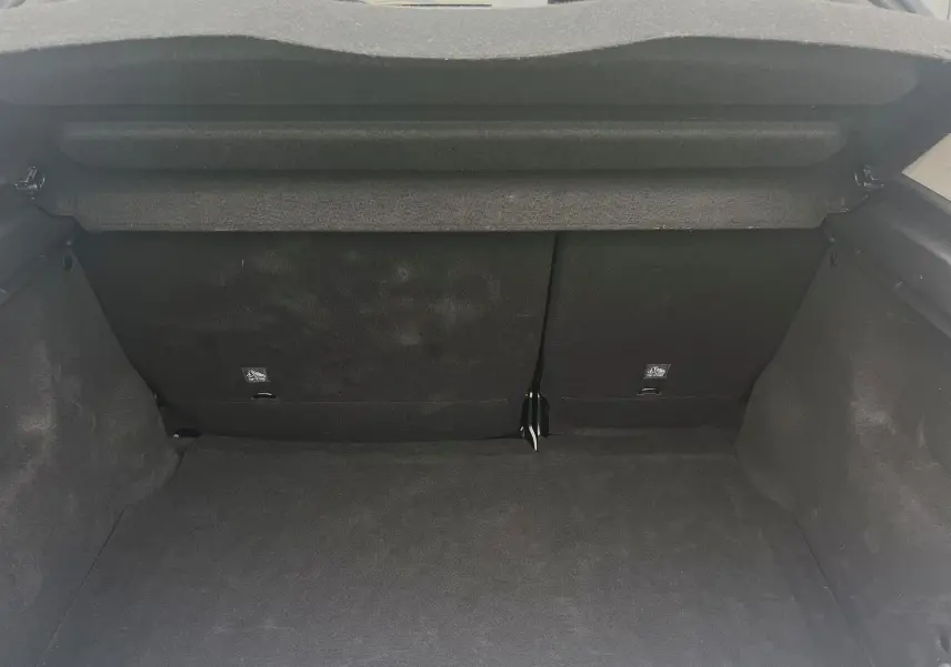 Coffre ouvert de Citroën C3 blanc 2017, vue intérieure arrière montrant la banquette arrière et le tapis de coffre noir.