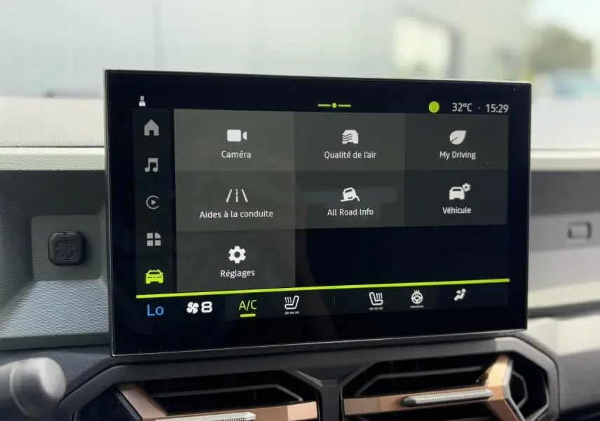 Écran tactile 10 pouces du tableau de bord du Dacia Duster 2025, affichant les réglages de conduite et climatisation