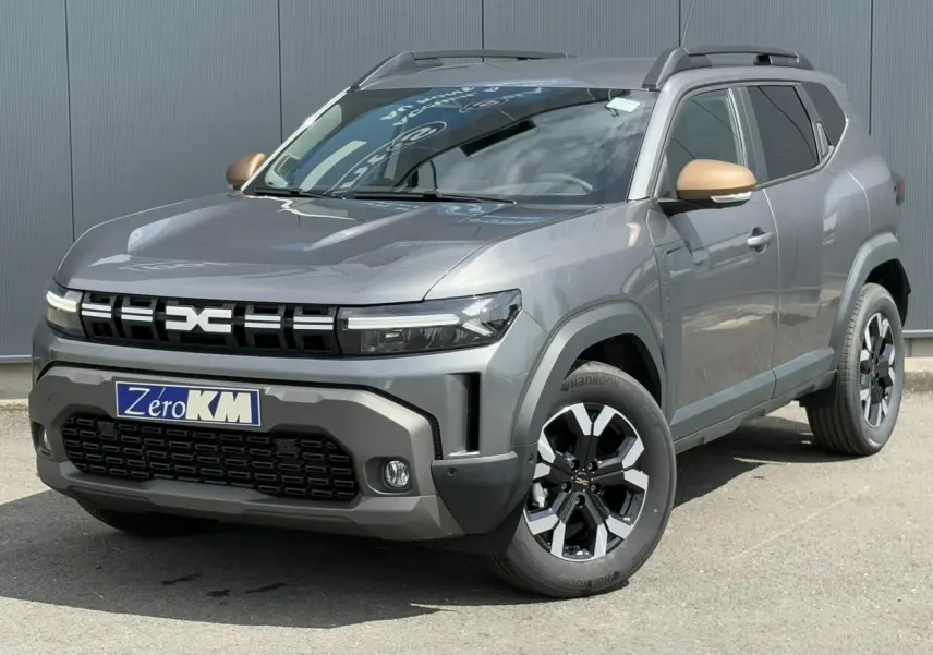 SUV Dacia Duster gris schiste en 3/4 avant droit avec coques de rétroviseurs brun cuivré et jantes alliage noires.