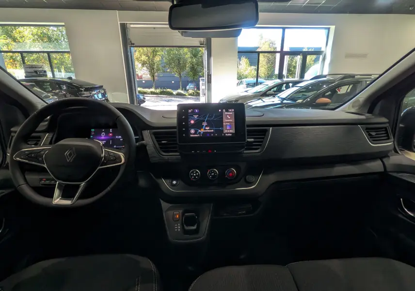Tableau de bord intérieur du Renault Trafic Combi gris comète 2025, avec écran tactile central et volant multifonction.