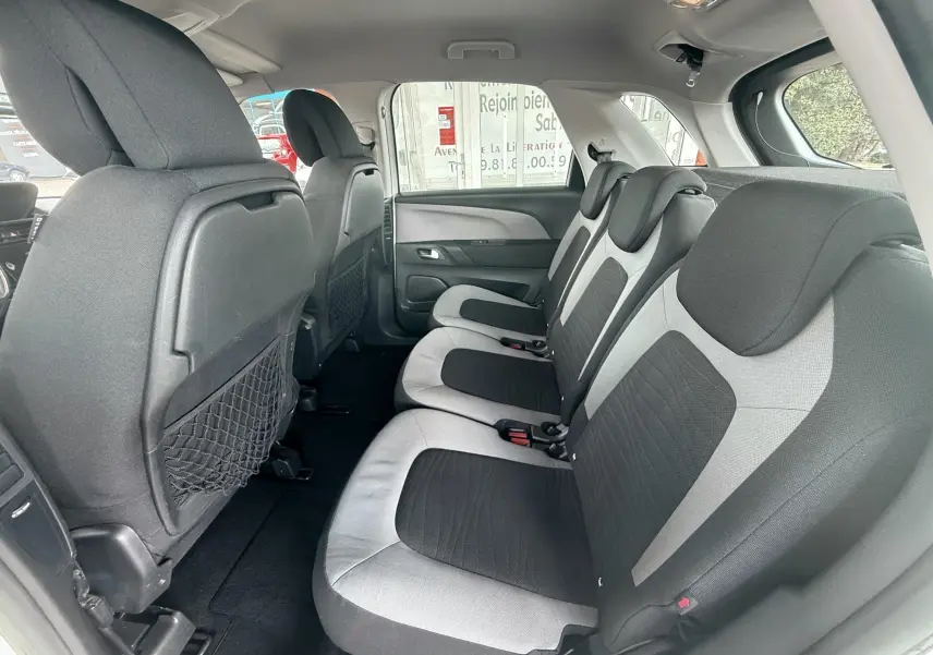 Vue intérieure côté droit des sièges arrière bi-ton gris et noir du Citroën C4 Picasso blanc de 2014.