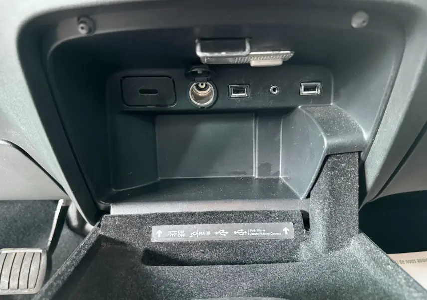 Vue rapprochée de la console centrale du Citroën C4 Picasso 2014, montrant les ports USB et prise allume-cigare.