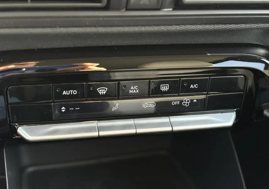 Gros plan sur les commandes de climatisation automatique en noir brillant dans le tableau de bord du Citroën C3 Aircross 2025.