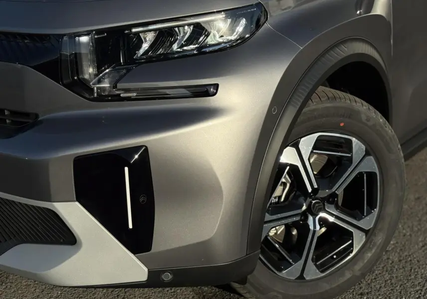 Gros plan sur l'avant droit gris Mercury du Citroën C3 Aircross 2025 avec phare LED et jante alliage noire et argent.