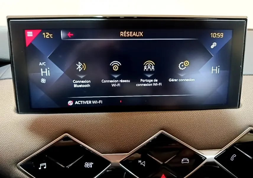 Écran tactile central du tableau de bord du DS3 Crossback bleu, affichant les options de connexion Wi-Fi et Bluetooth.