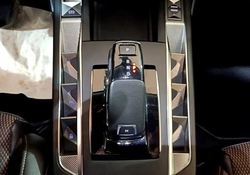 Gros plan sur la console centrale noire du DS3 Crossback avec levier de vitesses automatique et boutons de commandes latéraux.