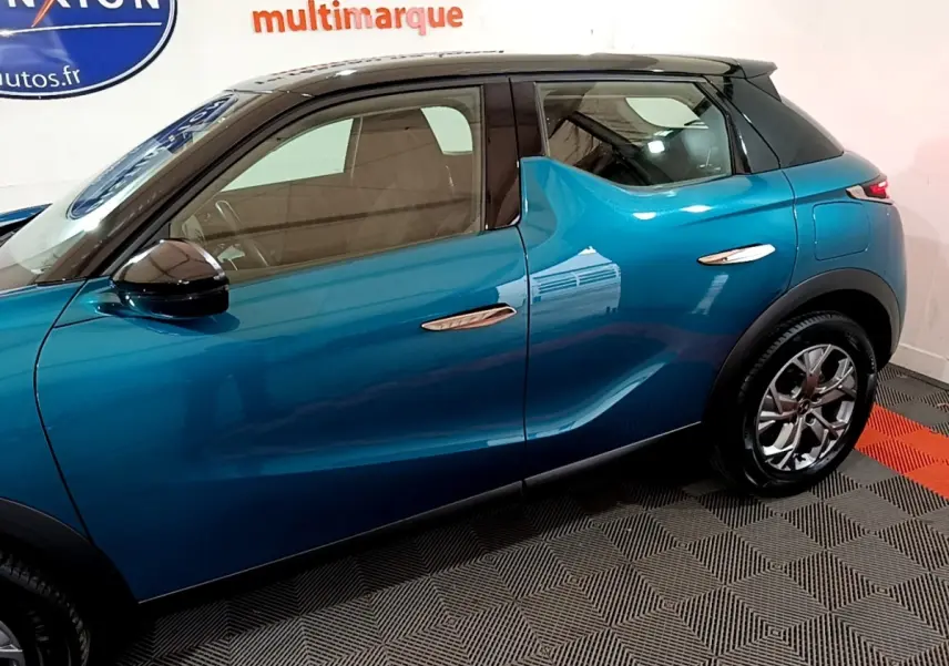 Vue latérale côté gauche du DS3 Crossback bleu avec toit noir et poignées de porte chromées.