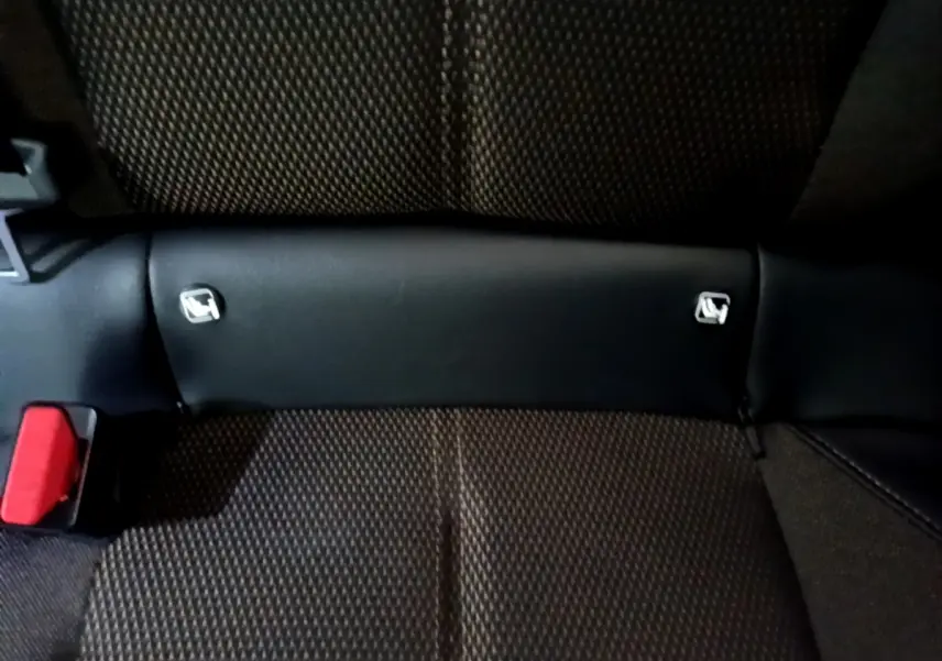 Gros plan sur la banquette arrière noire du DS3 Crossback avec attaches Isofix visibles et ceinture rouge.