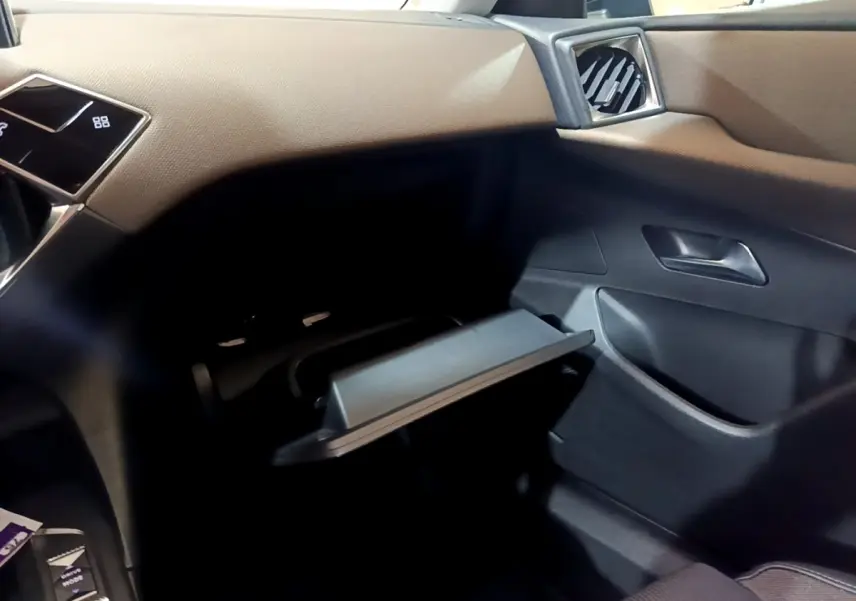 Intérieur du DS3 Crossback bleu, vue côté passager avec boîte à gants ouverte et tableau de bord beige.