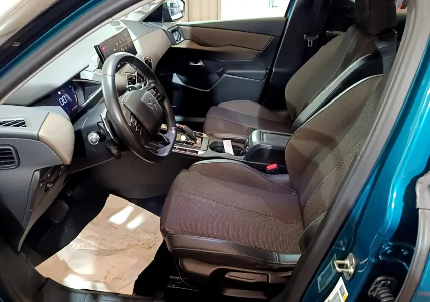 Intérieur du DS3 Crossback bleu, vue côté conducteur, sièges tissu marron et tableau de bord moderne avec écran tactile.