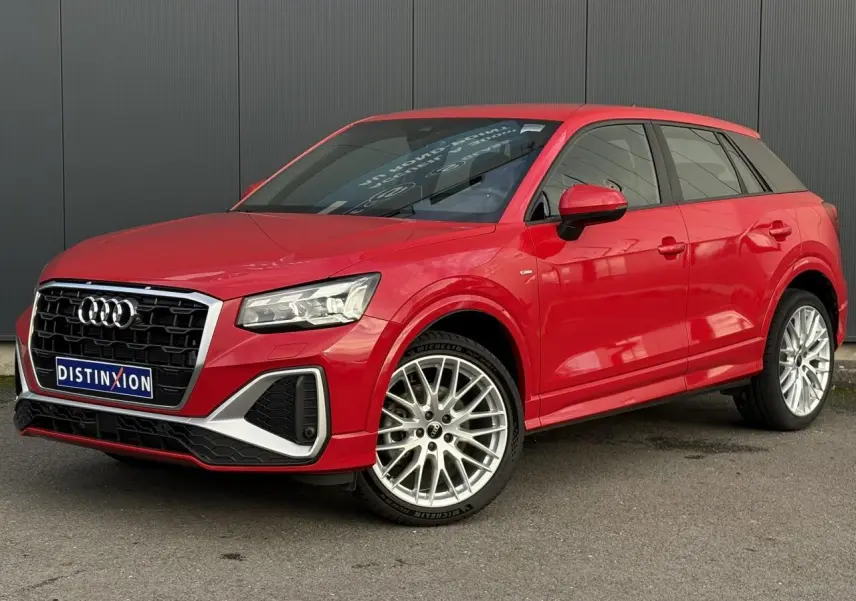 Audi Q2 35 TDI S-Line rouge vue 3/4 avant droit, avec jantes alliage et calandre noire distinctive.
