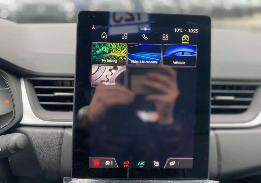 Écran tactile central du tableau de bord du Renault Captur 2025 avec interface multimédia et commandes climatisation visibles.