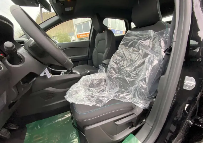 Vue intérieure côté conducteur du Renault Captur noir étoilé 2025, siège avant protégé par une housse plastique.
