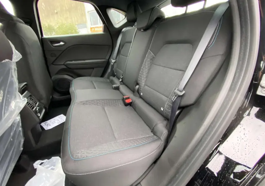 Vue intérieure côté droit des sièges arrière noirs avec surpiqûres bleues du Renault Captur 2025 Noir Étoile.