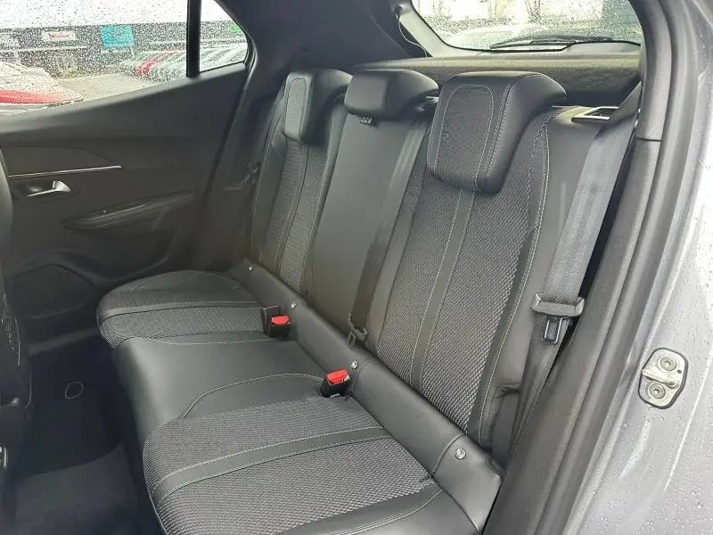 Vue intérieure côté droit des sièges arrière en tissu gris et cuir du Peugeot 2008 1.2 Hybrid 145ch GT 2025.
