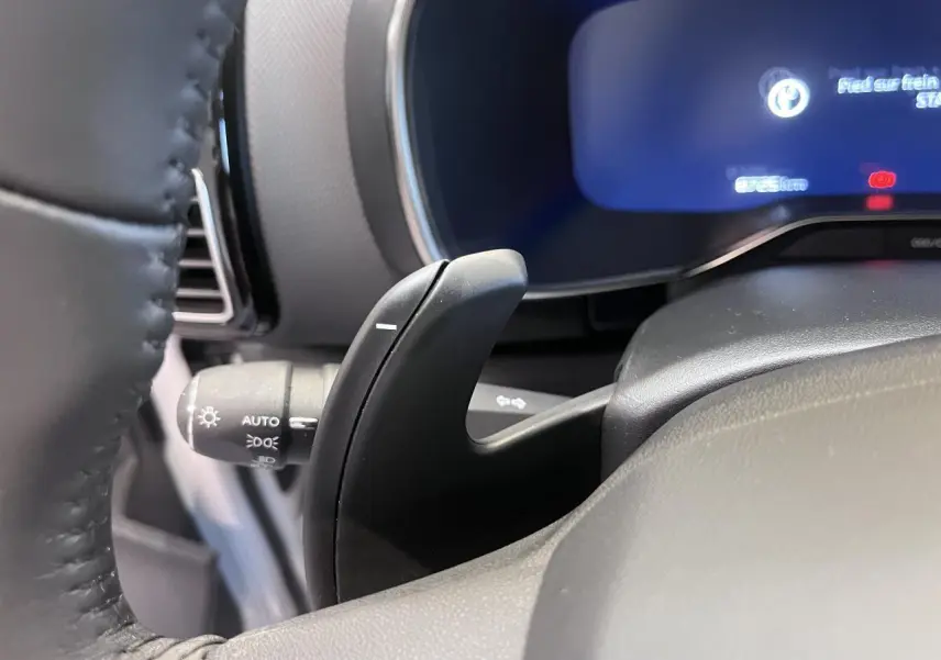 Gros plan sur la palette de changement de vitesse noire côté volant du tableau de bord gris du Citroën C5 Aircross.