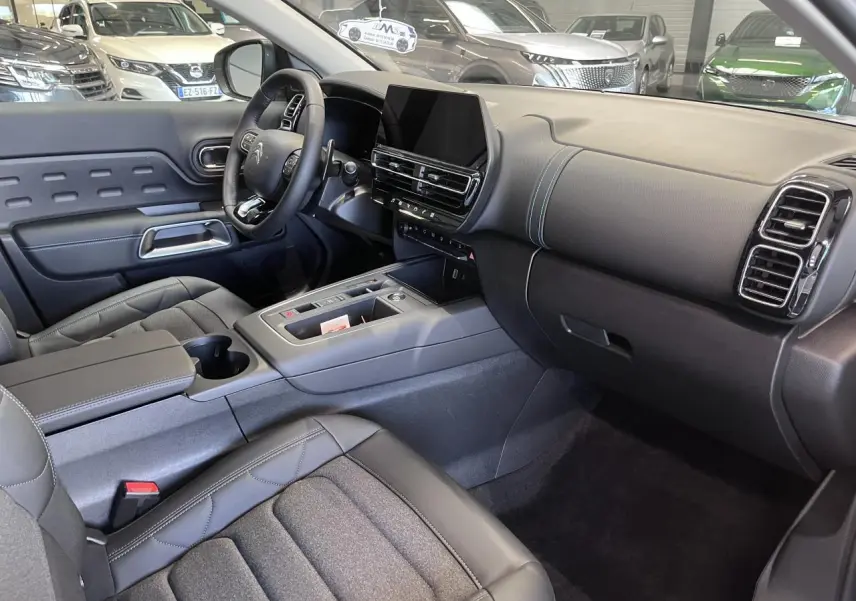 Intérieur avant du Citroën C5 Aircross gris platinium, avec tableau de bord moderne et sièges Advanced Comfort noirs.