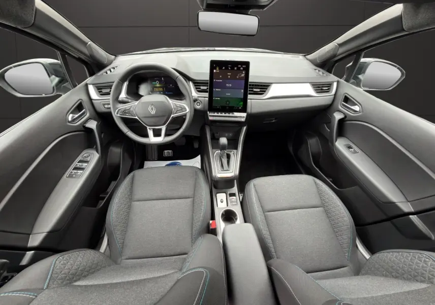 Vue intérieure avant du Renault SYMBIOZ noir, mettant en valeur le volant multifonctions et l'écran tactile central vertical.